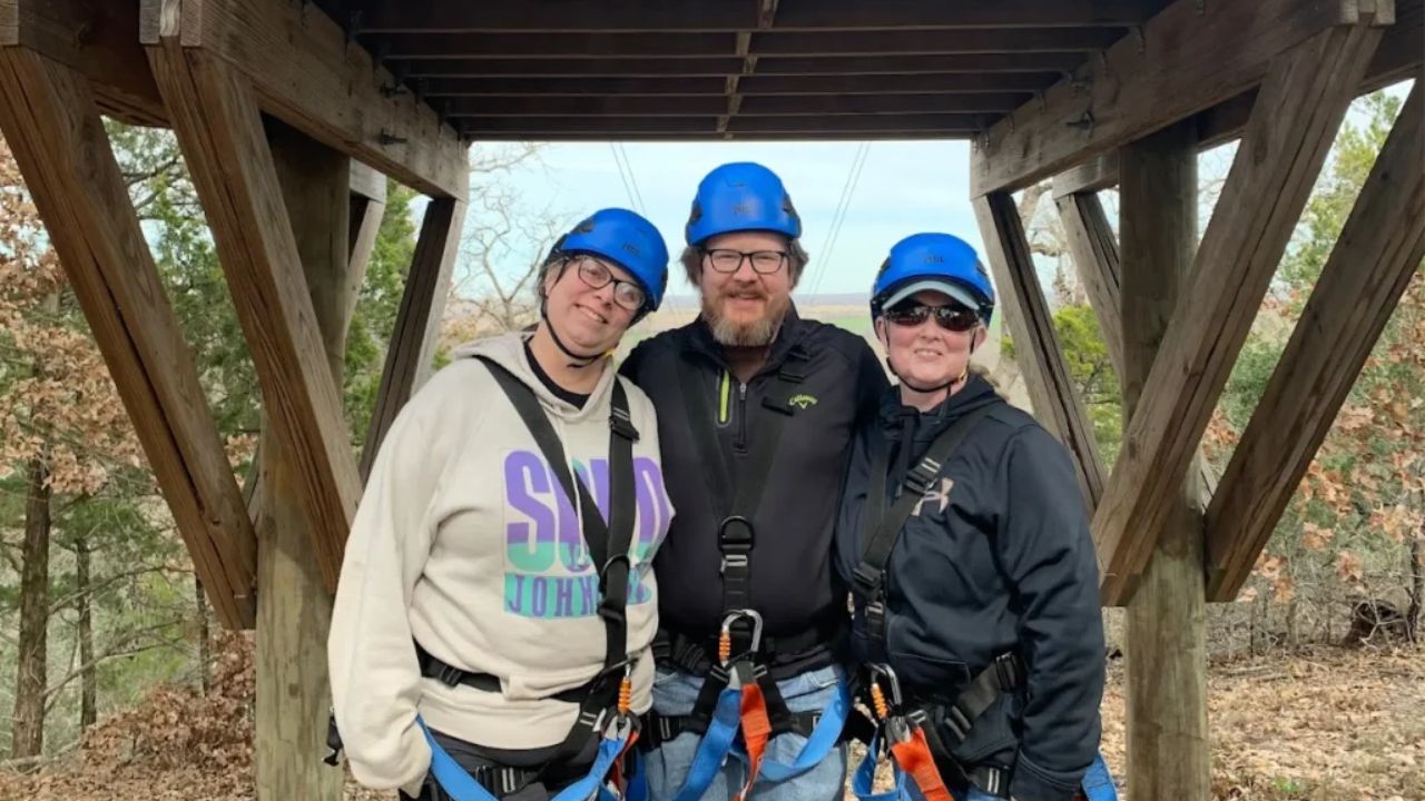 Group of people standing together and posing for a photo before their zipline adventure.