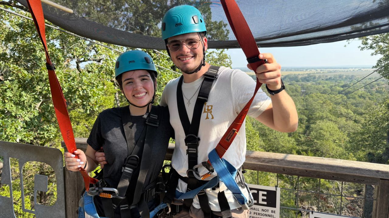Smiling couple at Zip Lost Pines surrounded by the scenic Texas Lost Pines forest.