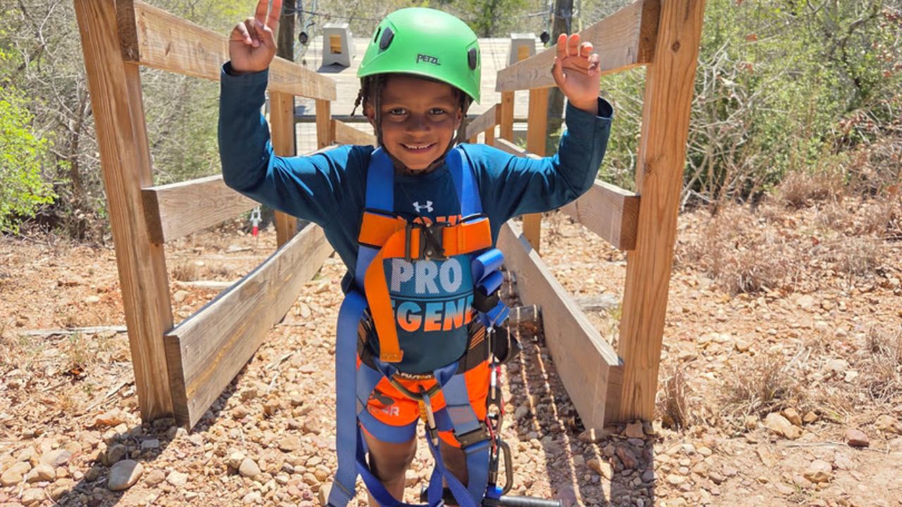 Young child enjoying a zipline adventure at Zip Lost Pines
