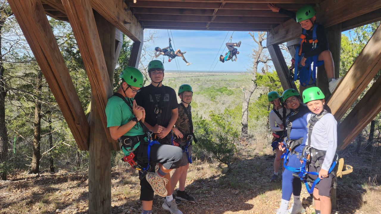 People enjoying a thrilling zipline adventure through the trees.
