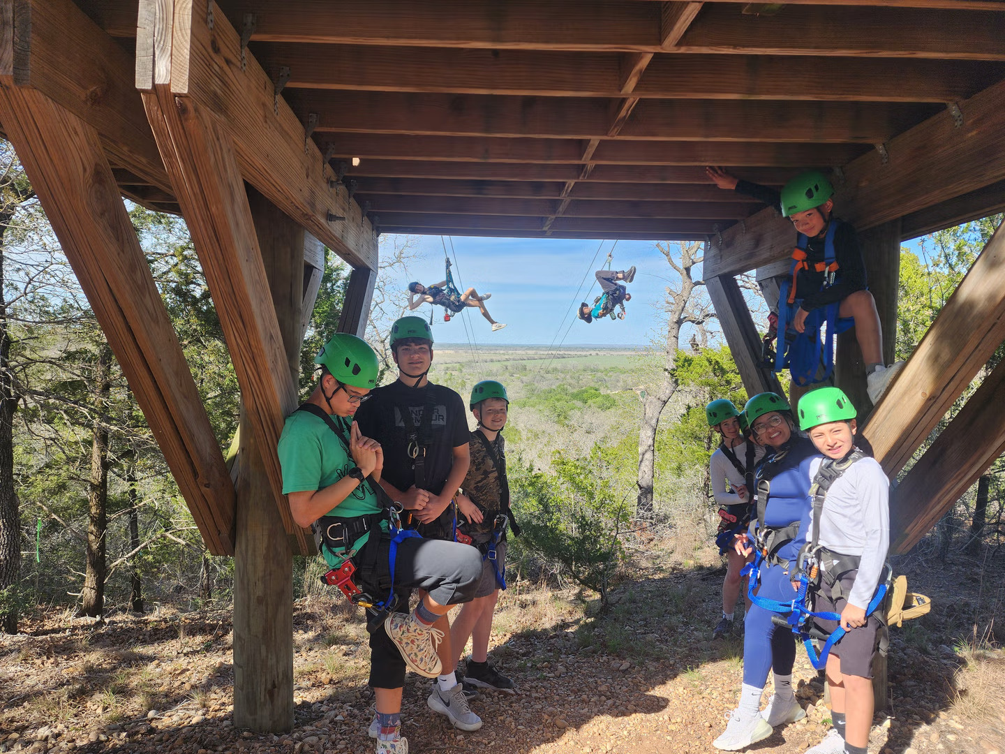Children and adults posing together for a zipline adventure