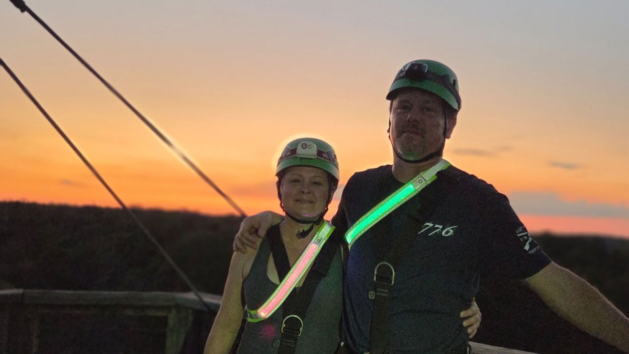 Visitors posing together during a zipline adventure in Lost Pines
