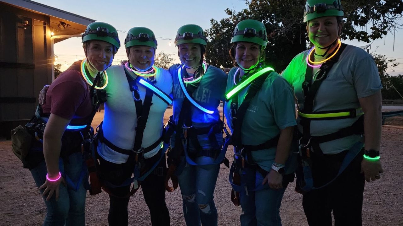 Group enjoying an evening zipline adventure at Zip Lost Pines
